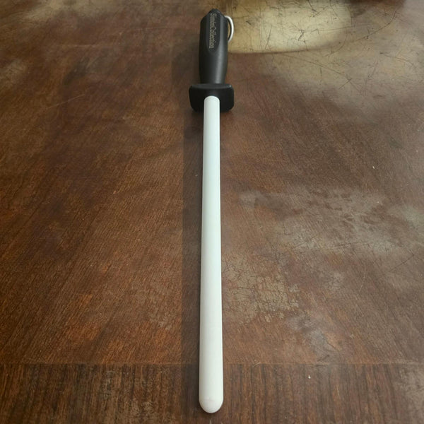 White Ceramic Sharpening Rod with black soft-grip handle and protective guard on a wood cutting board
